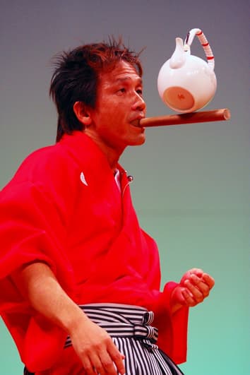 くわえたバチの上に土瓶を載せバランスをとる様子